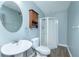 Bathroom featuring a pedestal sink, toilet, walk-in shower and wooden storage cabinet at 977 Forest Knoll Ct, Lithia Springs, GA 30122
