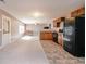 Open-concept kitchen with black appliances, a breakfast bar, and tile floors at 977 Forest Knoll Ct, Lithia Springs, GA 30122