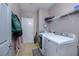 Functional laundry room with a washer, dryer, shelving, and space for storage and organizing at 977 Forest Knoll Ct, Lithia Springs, GA 30122