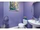 Stylish powder room with a pedestal sink, round mirror, and charming decor at 977 Forest Knoll Ct, Lithia Springs, GA 30122