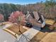An aerial showcases a manicured lawn, two-car garage, brick exterior, and mature trees at 2143 Great Shoals Cir, Lawrenceville, GA 30045