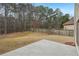 Large backyard with a fence, a concrete patio, and beautiful natural forest in the background at 2143 Great Shoals Cir, Lawrenceville, GA 30045