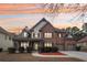 A beautiful brick home with a well-manicured lawn and three-car garage at sunset at 2143 Great Shoals Cir, Lawrenceville, GA 30045