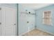 Bright laundry room featuring ceramic tile flooring, shelving, and a window for natural light at 2143 Great Shoals Cir, Lawrenceville, GA 30045