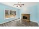 Living room with stone fireplace, ceiling fan, and natural light from many windows at 2143 Great Shoals Cir, Lawrenceville, GA 30045