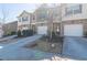 A row of townhomes featuring brick and neutral siding, each with a single-car garage and landscaping at 3293 Pennington Dr, Stonecrest, GA 30038