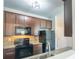 Kitchen featuring dark cabinets, stainless steel appliances, and granite countertops with modern lighting at 3293 Pennington Dr, Stonecrest, GA 30038