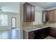 Well-lit kitchen with granite countertops, dark cabinetry, and stainless steel appliances next to an open living area at 3293 Pennington Dr, Stonecrest, GA 30038