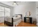 Cozy bedroom featuring hardwood floors, a window with blinds, and a black accent desk at 101 Terrace Dr, Atlanta, GA 30305