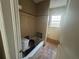 Bathroom with vintage tile, bathtub with missing toilet, and a window for light at 1907 Langston Sw Ave, Atlanta, GA 30310