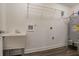 Utility sink, water heater, and storage shelves are located in the laundry room with wood-look floors at 2304 Wesley Chapel Rd, Decatur, GA 30035