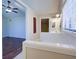 View of the ensuite bathroom with a double vanity, tile surround, and a glimpse of the bedroom at 3550 Beaver Cove Rd, Cumming, GA 30041