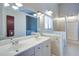 Well-lit bathroom featuring a double vanity, large mirrors, and a separate shower and tub at 3550 Beaver Cove Rd, Cumming, GA 30041