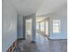 Hallway leading to living room with damaged walls and modern gray flooring at 6381 Phillips Creek Dr, Lithonia, GA 30058