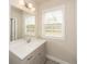 Bathroom vanity with gray cabinets, white countertop, and a large mirror and light fixture at 951 Olmsted Ln, Johns Creek, GA 30097