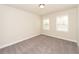Bright bedroom featuring neutral carpet, white walls, and two windows at 951 Olmsted Ln, Johns Creek, GA 30097
