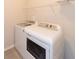 Bright laundry room featuring modern, front load, white washer and dryer set at 951 Olmsted Ln, Johns Creek, GA 30097