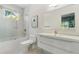 Modern all-white bathroom with tub and shower, floating sink, and bright window at 1002 Citadel Ne Dr, Atlanta, GA 30324