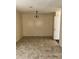 Open-plan dining area with tile floor, a classic chandelier, and neutral walls at 3636 Hopkins Ct, Powder Springs, GA 30127