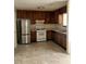 Functional kitchen with stainless steel refrigerator, gas range, and dark wood cabinetry at 3636 Hopkins Ct, Powder Springs, GA 30127