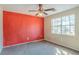 Spacious bedroom with natural light, ceiling fan and bright red accent wall ready to be styled at 7592 Didwell Ct, Jonesboro, GA 30236