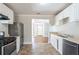 Bright kitchen features white cabinets, black appliances, and tiled floors at 940 Blair Bridge Rd, Austell, GA 30168