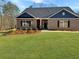 Charming brick home with dark blue accents, a manicured lawn, and inviting front entrance at 3402 Milan Ct, Douglasville, GA 30135