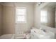 Tiled bathroom with neutral tones, a window, and a white sink vanity at 473 Oakside Sw Dr, Atlanta, GA 30331