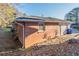 Brick home exterior featuring a small window and white trim with a sloped yard at 473 Oakside Sw Dr, Atlanta, GA 30331