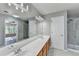 Bright bathroom featuring a double sink vanity, large mirror, and glass shower door at 1064 Wenham Ln, Lawrenceville, GA 30044