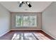 Bright bedroom featuring hardwood floors, a ceiling fan and a large window at 1064 Wenham Ln, Lawrenceville, GA 30044