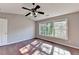 The bright bedroom has vaulted ceilings, hardwood floors, a ceiling fan and large window at 1064 Wenham Ln, Lawrenceville, GA 30044