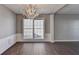 Dining area featuring a modern chandelier, large windows, chair rail, and hardwood flooring at 1064 Wenham Ln, Lawrenceville, GA 30044