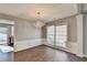 Dining room with hardwood floors, decorative chandelier, chair rail, and natural light at 1064 Wenham Ln, Lawrenceville, GA 30044