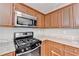 Kitchen with granite countertops, stainless steel appliances, and wood cabinets at 1064 Wenham Ln, Lawrenceville, GA 30044