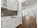 Close up shot of a bar area with white cabinets, marble countertops, and herringbone backsplash at 9089 Hanover St, Lithia Springs, GA 30122