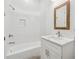 Bright bathroom features a shower over tub and a wooden framed mirror above the vanity at 9089 Hanover St, Lithia Springs, GA 30122