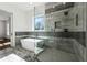 Contemporary bathroom featuring a luxurious soaking tub, a seamless glass shower and a bright window at 9089 Hanover St, Lithia Springs, GA 30122