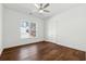 Clean bedroom featuring hardwood floors, white walls, a ceiling fan, and natural light at 9089 Hanover St, Lithia Springs, GA 30122