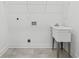 Simple laundry room with a utility sink, white walls, and wire shelving at 9089 Hanover St, Lithia Springs, GA 30122