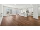 Open-concept living room featuring hardwood floors, white walls, fireplace, kitchen island and natural light at 9089 Hanover St, Lithia Springs, GA 30122
