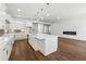 Modern living room featuring hardwood floors, a large kitchen island, stainless steel appliances and fireplace at 9089 Hanover St, Lithia Springs, GA 30122