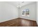 Empty, sunlit room features hardwood flooring and a large window with neighborhood view at 9089 Hanover St, Lithia Springs, GA 30122