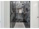 Luxurious walk-in shower with elegant dark marble, a built-in niche, and upscale fixtures for relaxation at 9089 Hanover St, Lithia Springs, GA 30122