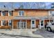 Brick townhome with covered front porch and parking, showcasing classic architectural details at 933 Carla Pl, Norcross, GA 30093