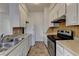 Galley kitchen with white cabinets, laminate countertops, and stainless steel oven at 933 Carla Pl, Norcross, GA 30093
