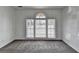 Bright living room with neutral carpeting and large, arched window at 933 Carla Pl, Norcross, GA 30093