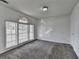 Sun-filled living room featuring neutral carpeting and a large, arched window at 933 Carla Pl, Norcross, GA 30093