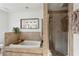 Bathroom with a large tub and tiled walk-in shower with a glass door, surrounded by neutral tile at 1898 Woodland Hills Nw Ave, Atlanta, GA 30318