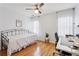 Bedroom with hardwood floors, a ceiling fan, a black daybed, desk, and white sheer curtains at 1898 Woodland Hills Nw Ave, Atlanta, GA 30318